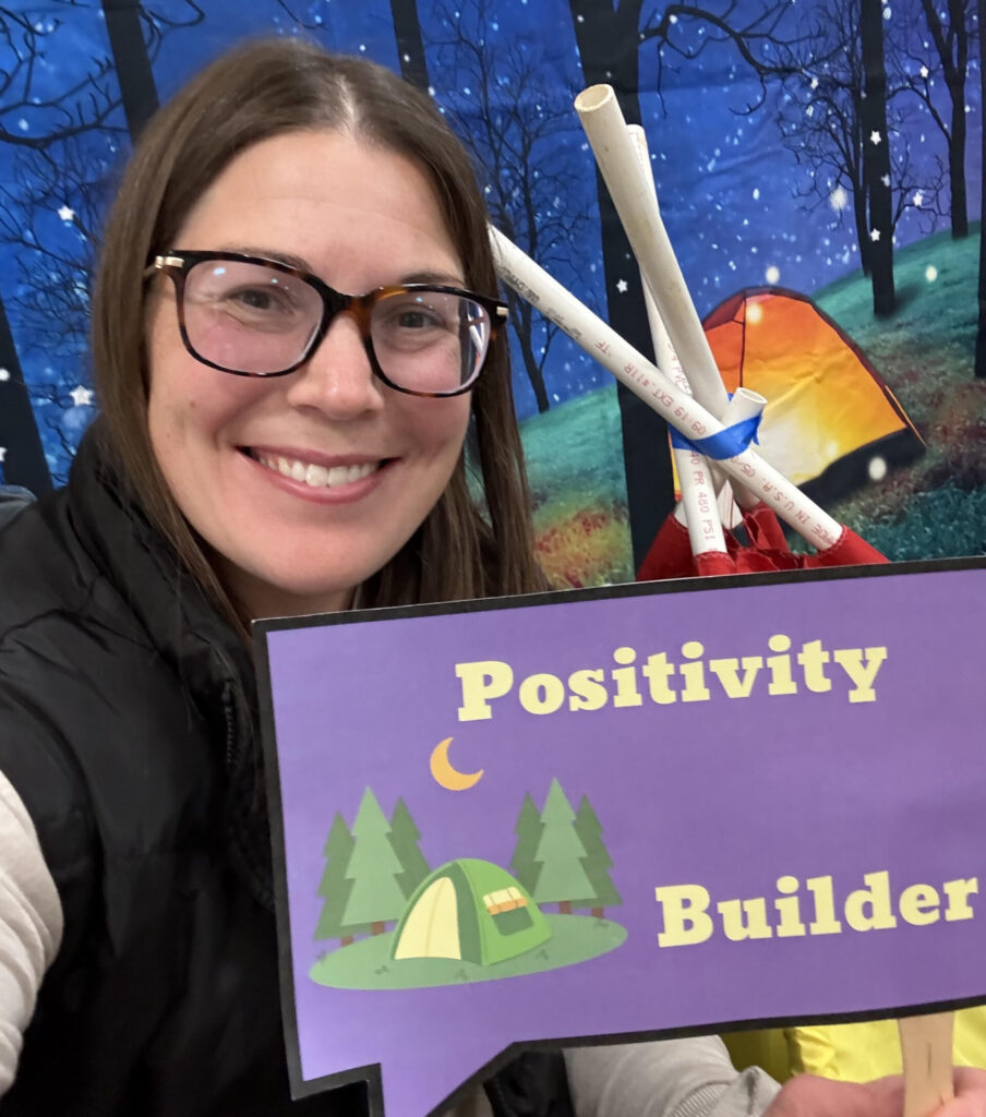 Person holding "Positivity Builder" sign