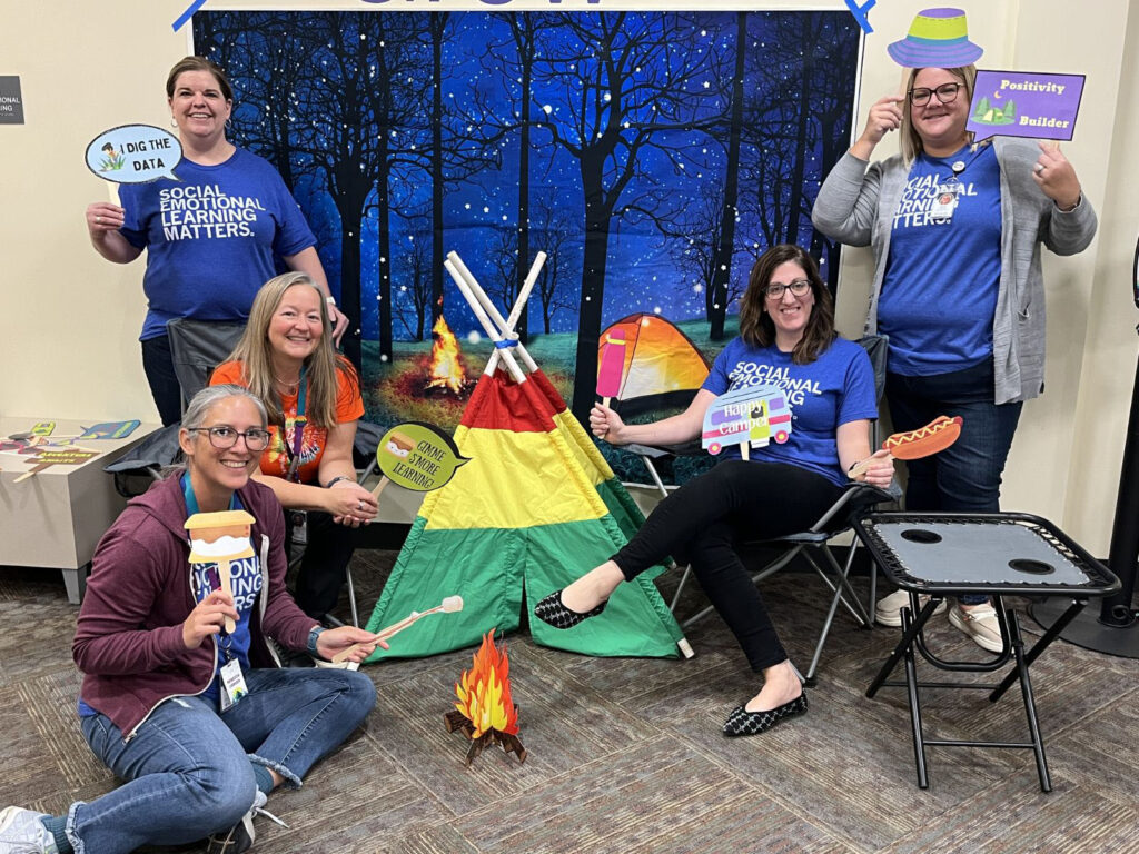 Five AEA staff sitting around tent